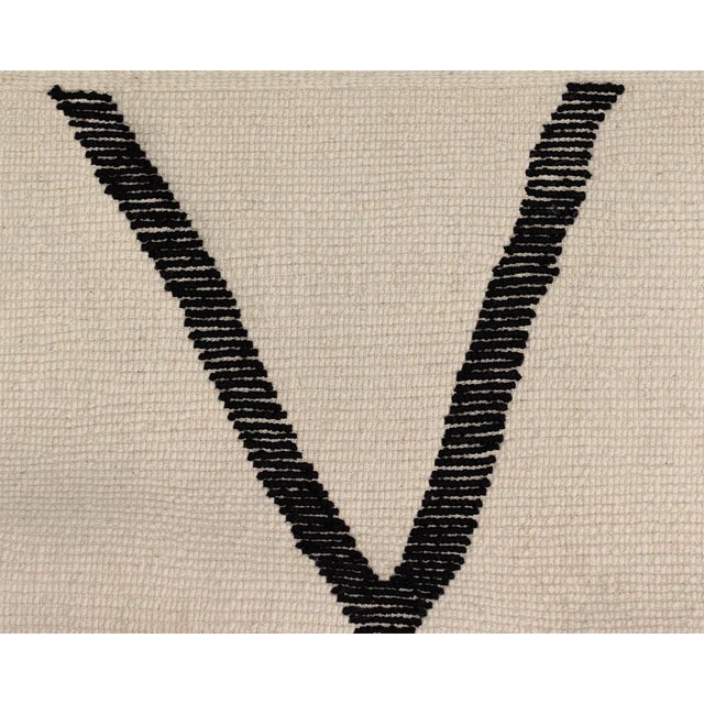 Sophisticated wool rug meticulously hand-knotted, showcasing an Ivory backdrop adorned with captivating Midnight Black...