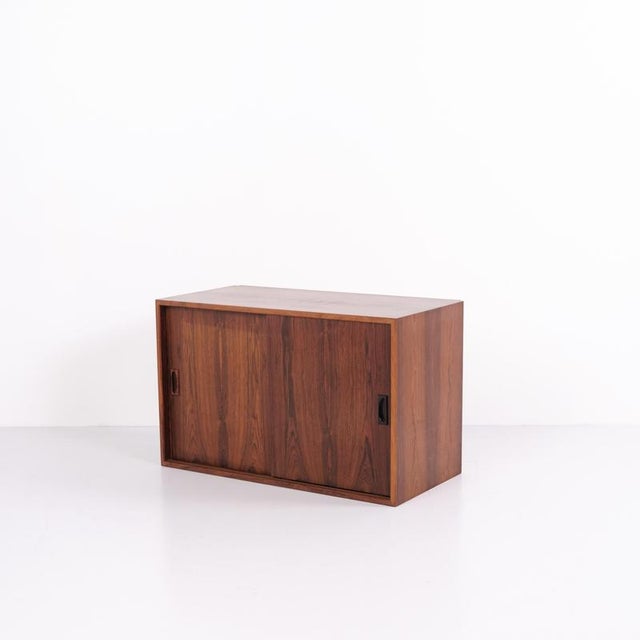 Danish design wall-mounted cabinet from the 1960s, made of rosewood. The cabinet features sliding doors and interior...