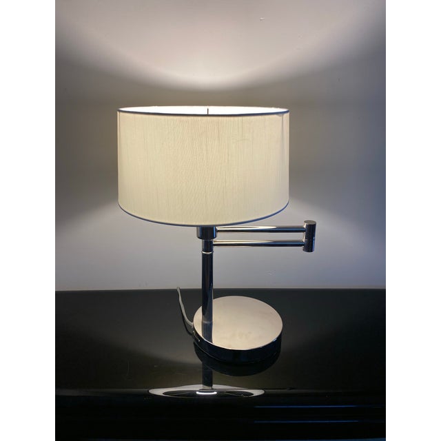 A chrome Ralph Lauren articulating table lamp with white linen shade. Perfect for a nightstand or desk