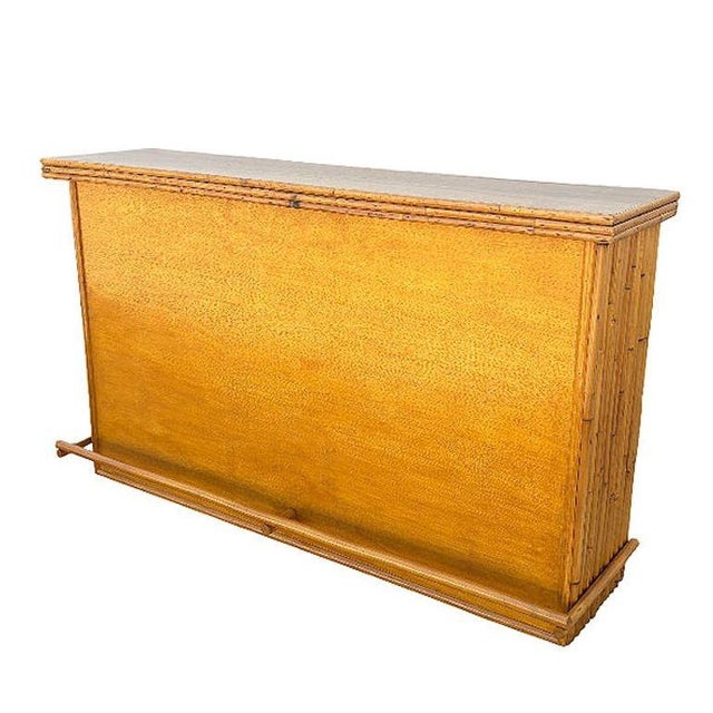Large 42" wide Mahogany wood dry bar with vertically stacked rattan sides and a Mahogany top. The bar has two shelves...