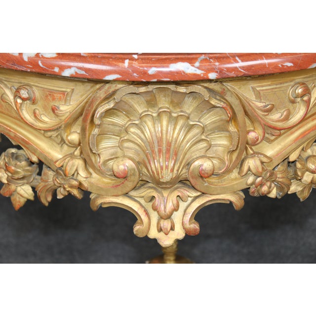 An extraordinary 19th century French Rococo carved giltwood console table, lavishly executed with dramatic sculptural...