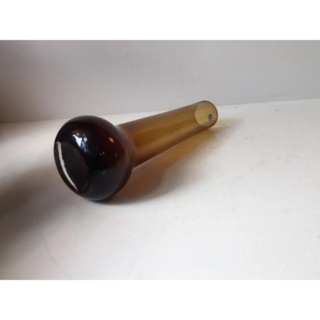 This cylindrical studio vase with globe-shaped base in yellow smoked glass was designed by Bo Bergström and manufactured...