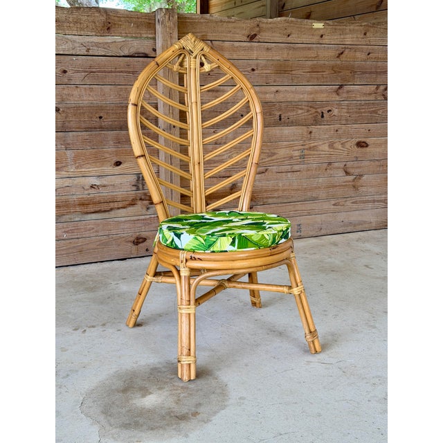 A beautifully sculptural vintage rattan side chair featuring an eye-catching leaf-form back, a signature detail that gives...