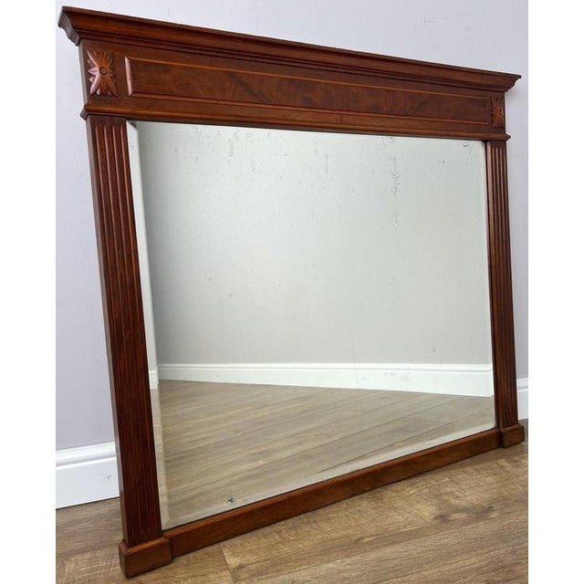 A characterful Antique French mirror featuring a substantial walnut frame, strong architectural lines and decorative...