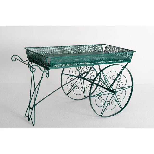 Large green painted wood and metal garden flower cart, with large decorative and functioning metal wheels. This cart is...