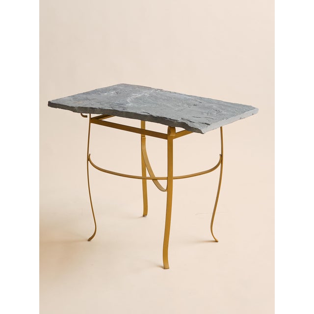 This console table pairs a natural slate top in an organic, freeform shape with a painted iron base in a warm yellow hue....