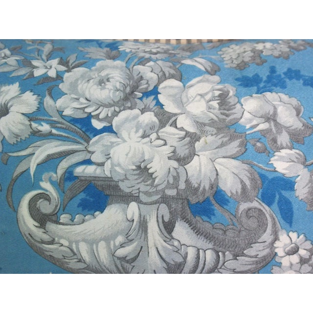 A pillow made from circa 1900 printed cotton, backed with coordinating linen and edged with a French check cotton.