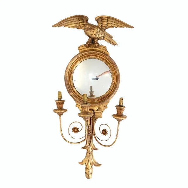 Pair of Neo Classical gilt wall displays surmounted by eagles One is a mirror and the other features a painted plaque...