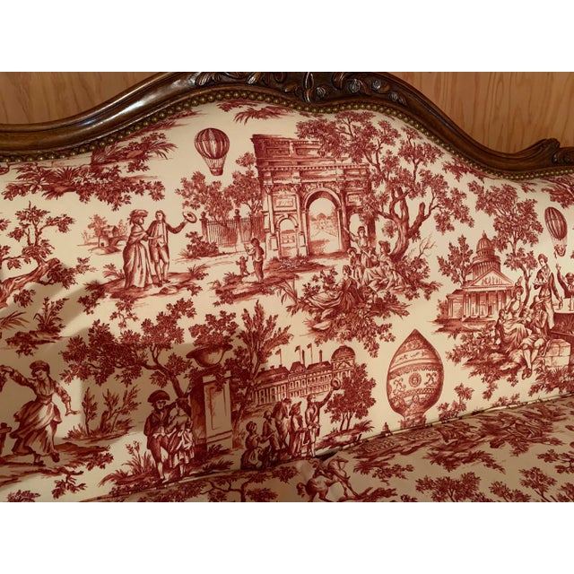 Louis XV style sofa with a walnut frame. Recently reupholstered in a red French toile with a down cushion.