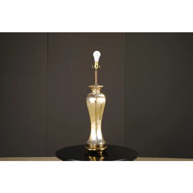 A refined and sculptural pair of Italian mercury glass table lamps, attributed to Murano, circa 1950s. These elegant lamps...