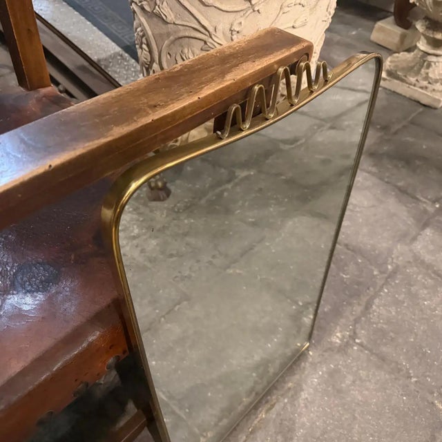 This exquisite mid-century modern brass shield wall mirror epitomizes the sophisticated design language of Gio Ponti, a...