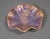 A hand-built studio pottery bowl with a sculptural wavy rim and richly layered glossy glaze. The surface blends lavender,...