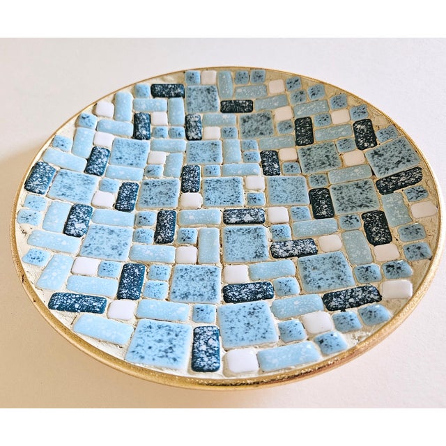 A decorative ceramic tile bowl featuring an interesting geometric design with colorful assorted shapes and sizes of...
