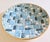 A decorative ceramic tile bowl featuring an interesting geometric design with colorful assorted shapes and sizes of...