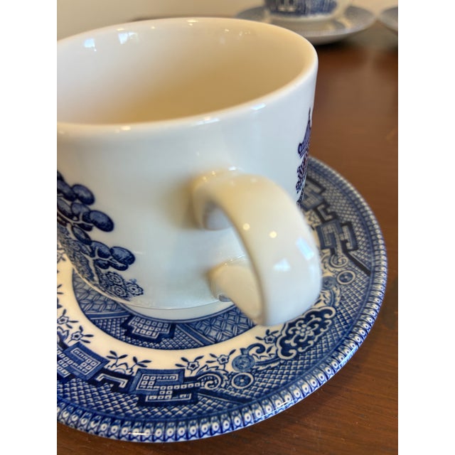 A charming set of four vintage Churchill England cups and matching saucers in a classic blue-and-white transferware...