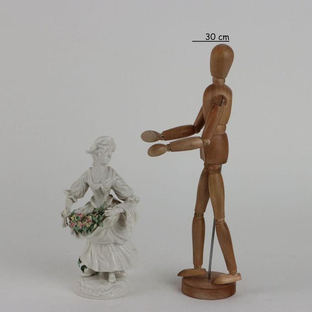 Porcelain figurine depicting a flower seller. Very accurate execution. Under the base the manufacturer's mark. This piece...