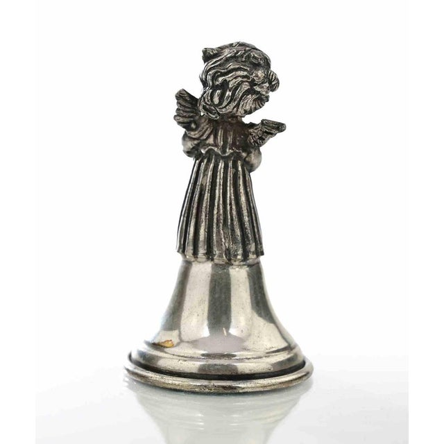 Charming vintage silver bell featuring a beautifully detailed cherub angel figure holding a pan flute atop a classic bell-...