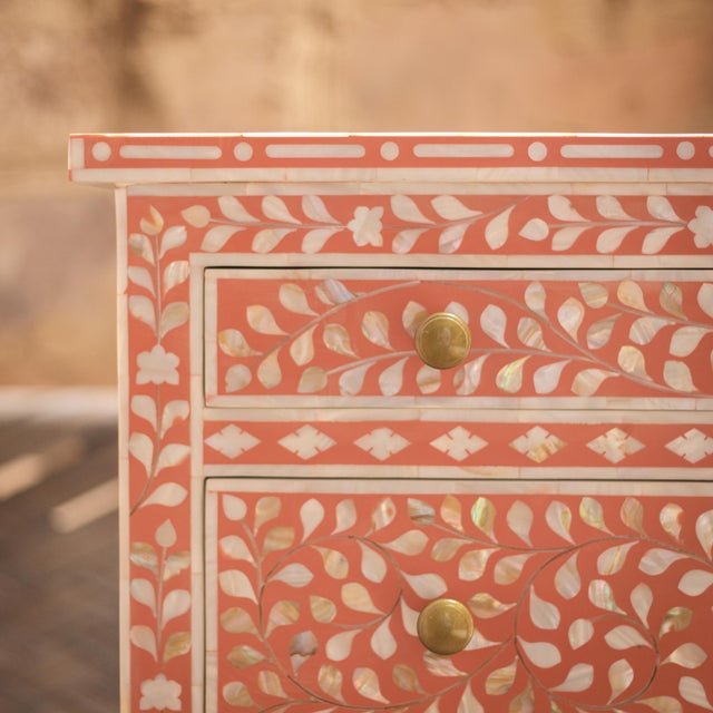 The Arabesque Mother of Pearl Inlay Five-Drawer Tallboy celebrates the expressive beauty of botanical ornamentation...