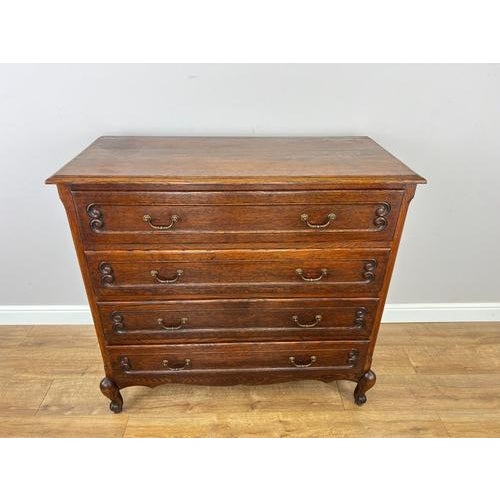 A handsome Vintage French Louis chest of drawers in oak, featuring four spacious drawers, decorative carved drawer fronts,...
