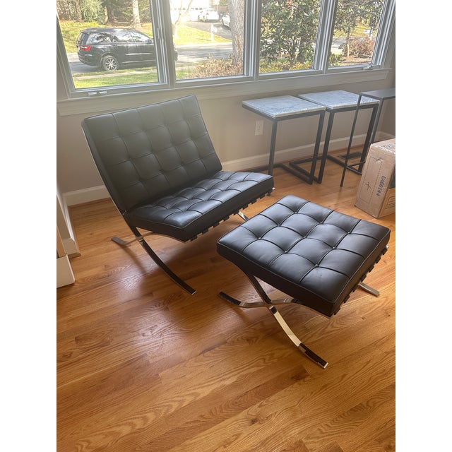 Elegant, modern lounge chair with matching ottoman in classic Barcelona-style design. Upholstered in black tufted leather...