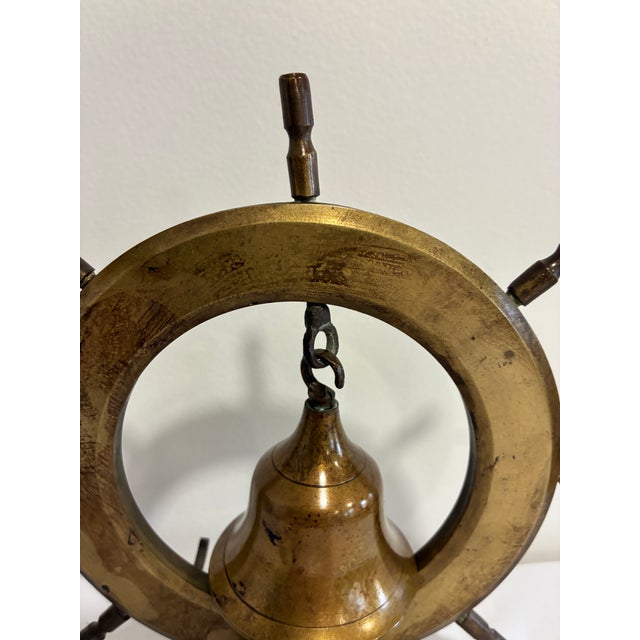 Chairish Description A handsome vintage brass ship's wheel with a small bell hanging at its center, mounted on a weighty...
