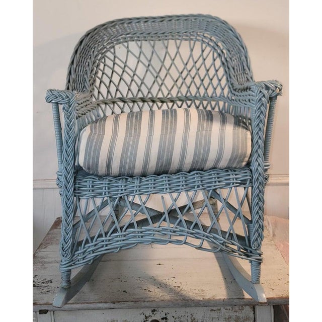 Bar Harbor wicker rocker with blue paint over the original mustard paint. Stripped custom made seat cushion