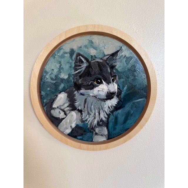 This circular oil painting on birch panel captures a contemplative cat, its striking green eyes gazing thoughtfully into...