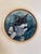This circular oil painting on birch panel captures a contemplative cat, its striking green eyes gazing thoughtfully into...