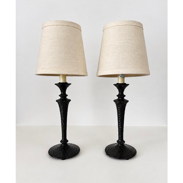 Pair of solid bronze or brass candlestick form lamps with a hammered or peened surface that and that is reminiscent of the...