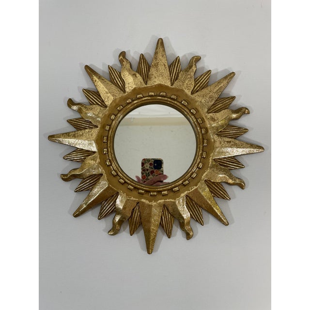 A stunning radiant resin Mid Century Modern gilded Sunburst Wall Mirror with varying lengths of rays. Circa Mid 1960s-70s....