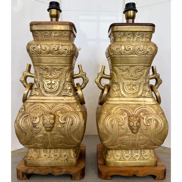 Pair of vintage Chinese archaistic brass table lamps from the 1940s, often attributed to the style of designer James Mont....