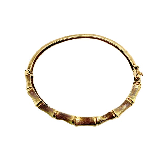 This 1960s bangle in 14K yellow gold has a sculpted bamboo design across the top half. Bamboo was a popular theme in mid-...