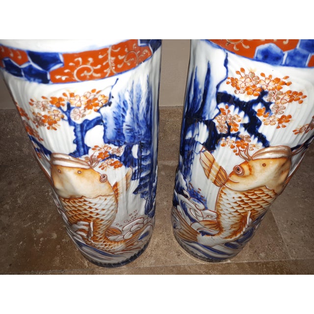 Exceptional and rare pair of Arita porcelain vases decorated with carp jumping out of the water near a waterfall. Richly...