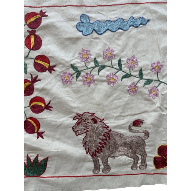 Hand-embroidered Suzani panel from Uzbekistan, worked in fine floss on a cream cotton ground. Three lions move across the...
