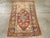 A vintage Turkish Anatolian throw rug. An abrashed red field is nearly filled by a rosette and carnation lozenge...