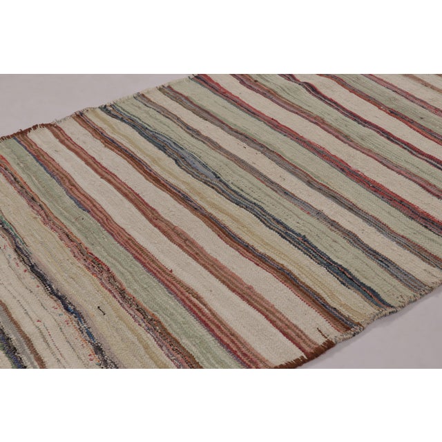 Handwoven in wool, by nomads of the Shahson clan, circa 1950-1960, this 5x8 vintage Kilim enjoying colorful stripes, is a...