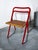 Beautiful mid-century folding chair by Giorgio Cattelan for Cidue, Italy. The chair features a red metal frame and seat...
