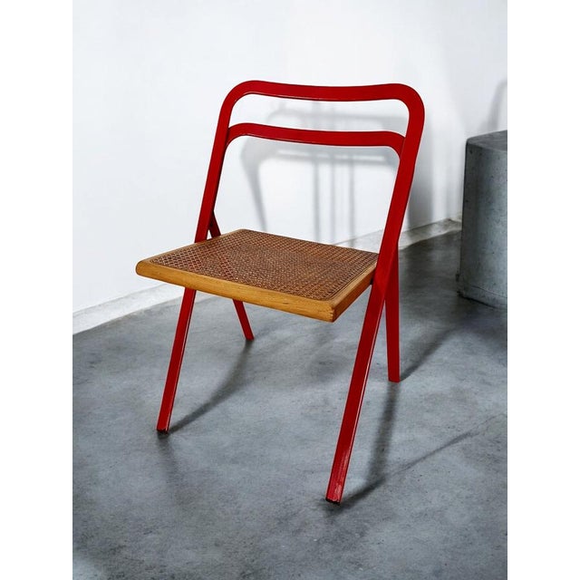 Beautiful mid-century folding chair by Giorgio Cattelan for Cidue, Italy. The chair features a red metal frame and seat...