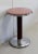 Small Circular Modern Pedestal Table, with cylindrical Iron shaft and Brushed Stainless Steel base. Its Top is composed or...