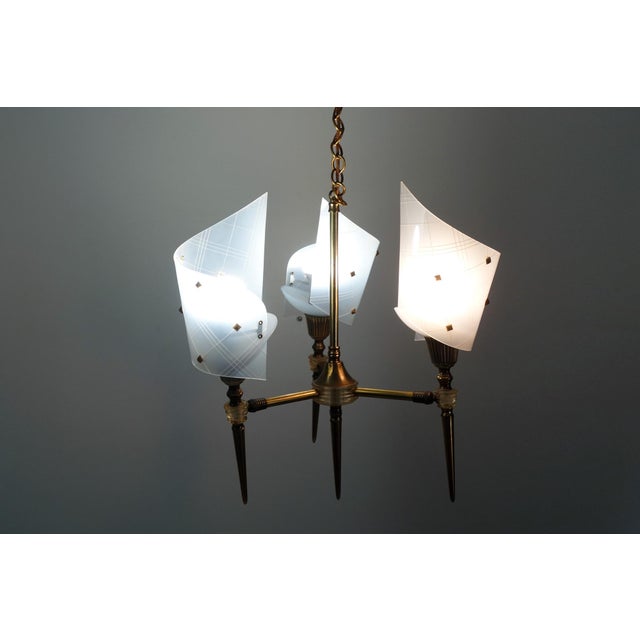 Three-light chandelier, 1950s/60s rockabilly style. Brass and clear plastic frame, Perspex shades mounted on adjustable...