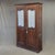 A gorgeous and functional antique 19th century French provincial oak wardrobe cabinet that features carved designs on the...