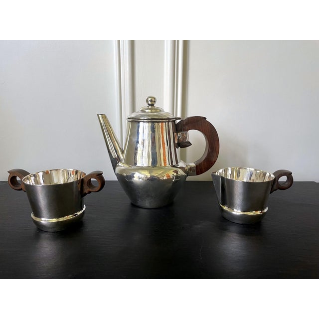 An early set of sterling silver coffee or tea set comprising a coffee or tea pot, a cream jug and an open sugar bowl....