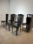 Elegant set of six vintage dining chairs upholstered in black leather. The design is defined by the tall, slightly tapered...