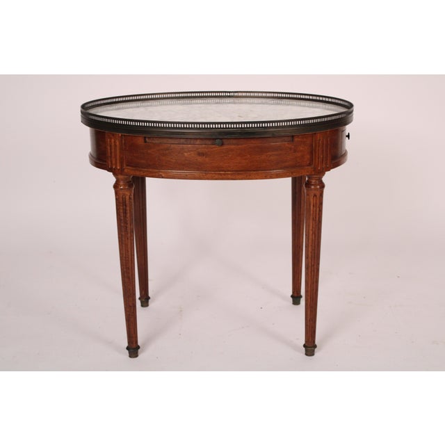 Louis XVI style beech wood bouillotte table with Carrara marble top, circa 1930's. With a reticulated brass gallery...