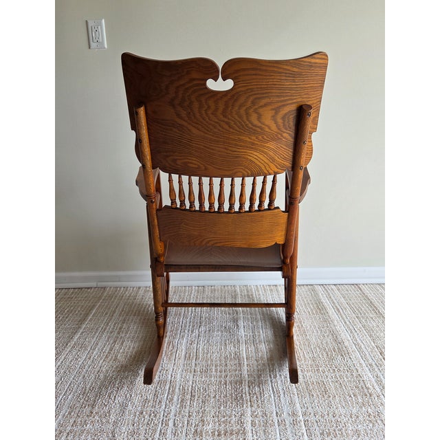 This is a wonderfully unique antique rocking chair. It has lovely details including carved spindles. Even the seat is...