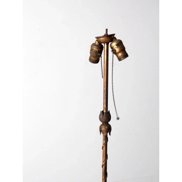 This is an early 20th century floor lamp. The art nouveau styled lamp features a decorative base with floral vining...