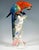 Highly decorative representation of a macaw perched on a tree trunk entwined with a climbing plant, leaning forward to...