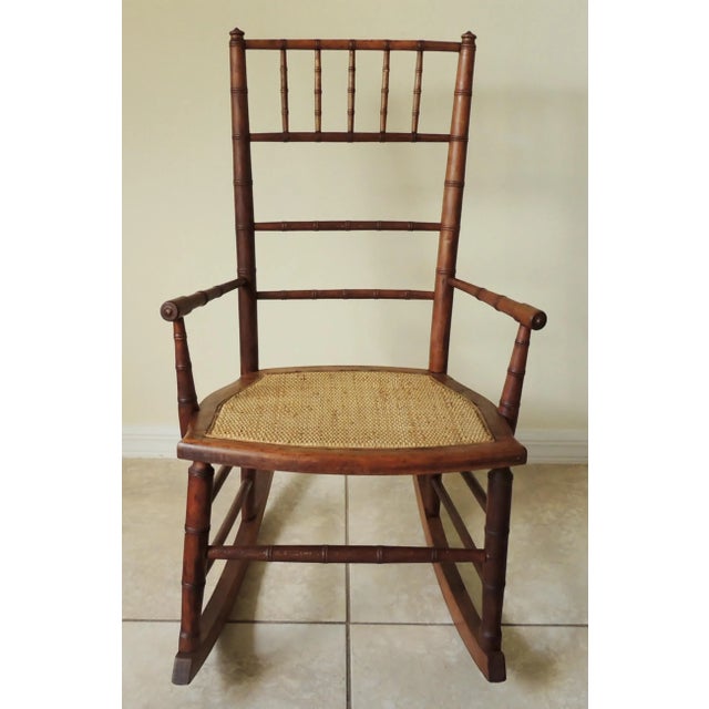 Wonderful antique early 20th century RJ Horner style faux bamboo child's rocking chair with cane seat. Solid wood rocker...