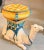 A show-stopping ceramic garden seat from Italy, sculpted in the form of a resting camel rendered in a rich ivory glaze...