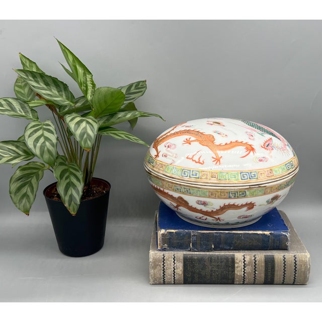 Exquisite, large Chinese porcelain covered box features a vibrant famille rose decoration of a dragon and phoenix amid...